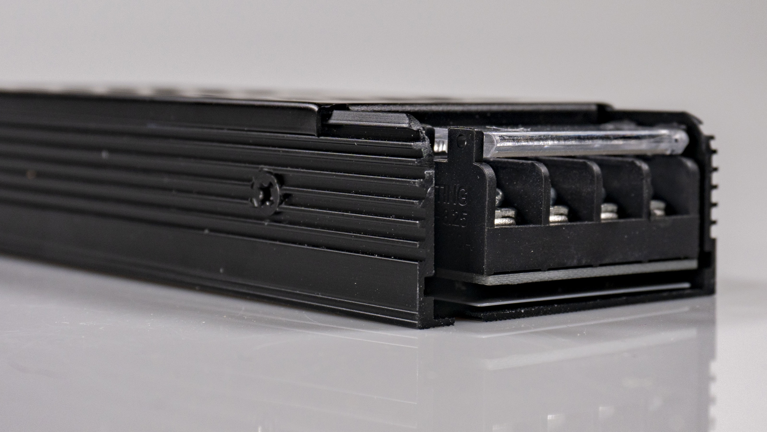 Close-up image of a black 100W, 24V power supply by Smart Systems Group, highlighting its compact and modern design.